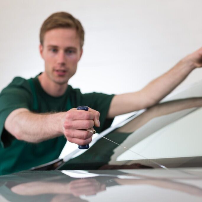 man cutting a windshield